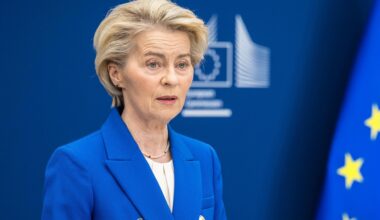 EU-Kommissionspräsidentin Ursula von der Leyen steht in EU-blauem Sakko neben der EU-Flagge an einem Rednerpult