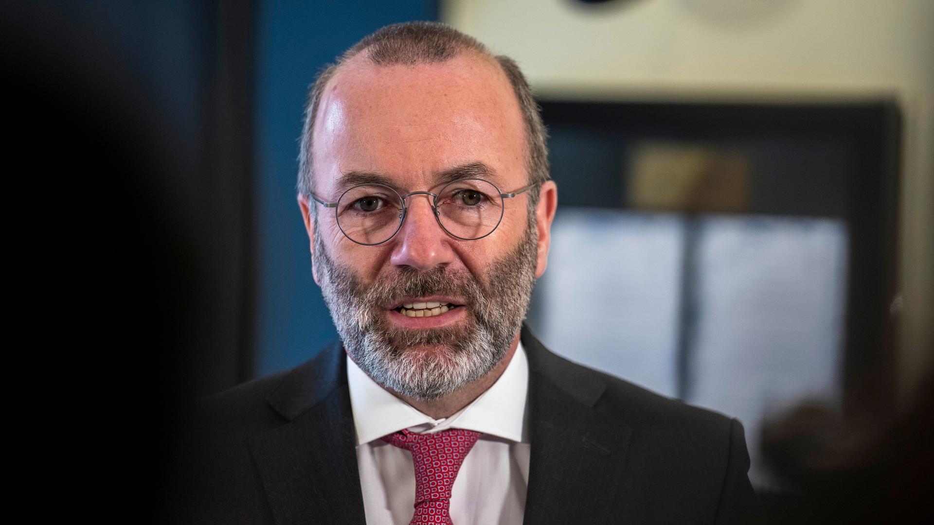 Porträt des EVP-Chefs Manfred Weber. Er trägt Brille und Bart, eine rote Krawatte zum schwarzen Anzug. 