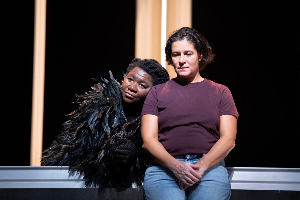 Zwei Frauen sitzen nebeneinander auf der Bühne.