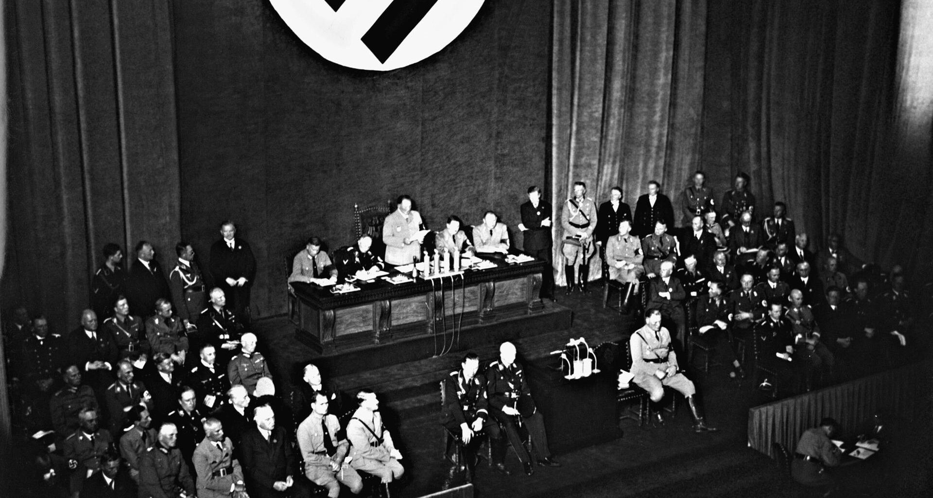 Ein historisches Schwarz-Weiß-Foto zeigt eine Reichstagssitzung am 15.09.1935 in Nürnberg. Hermann Göring steht in der Bildmitte hinten am Rednerpult.