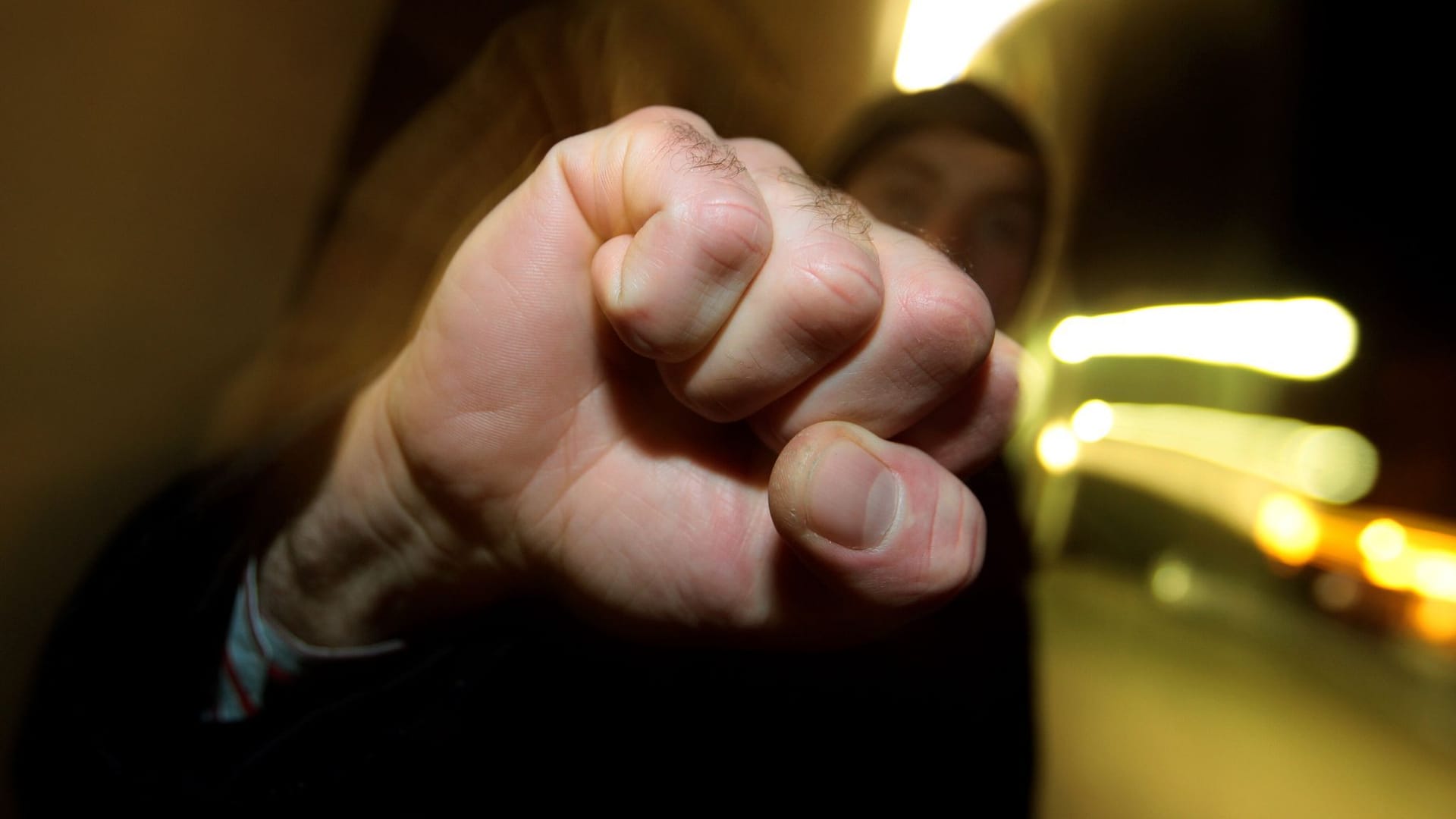 Junger Mann hebt seine geballte Faust