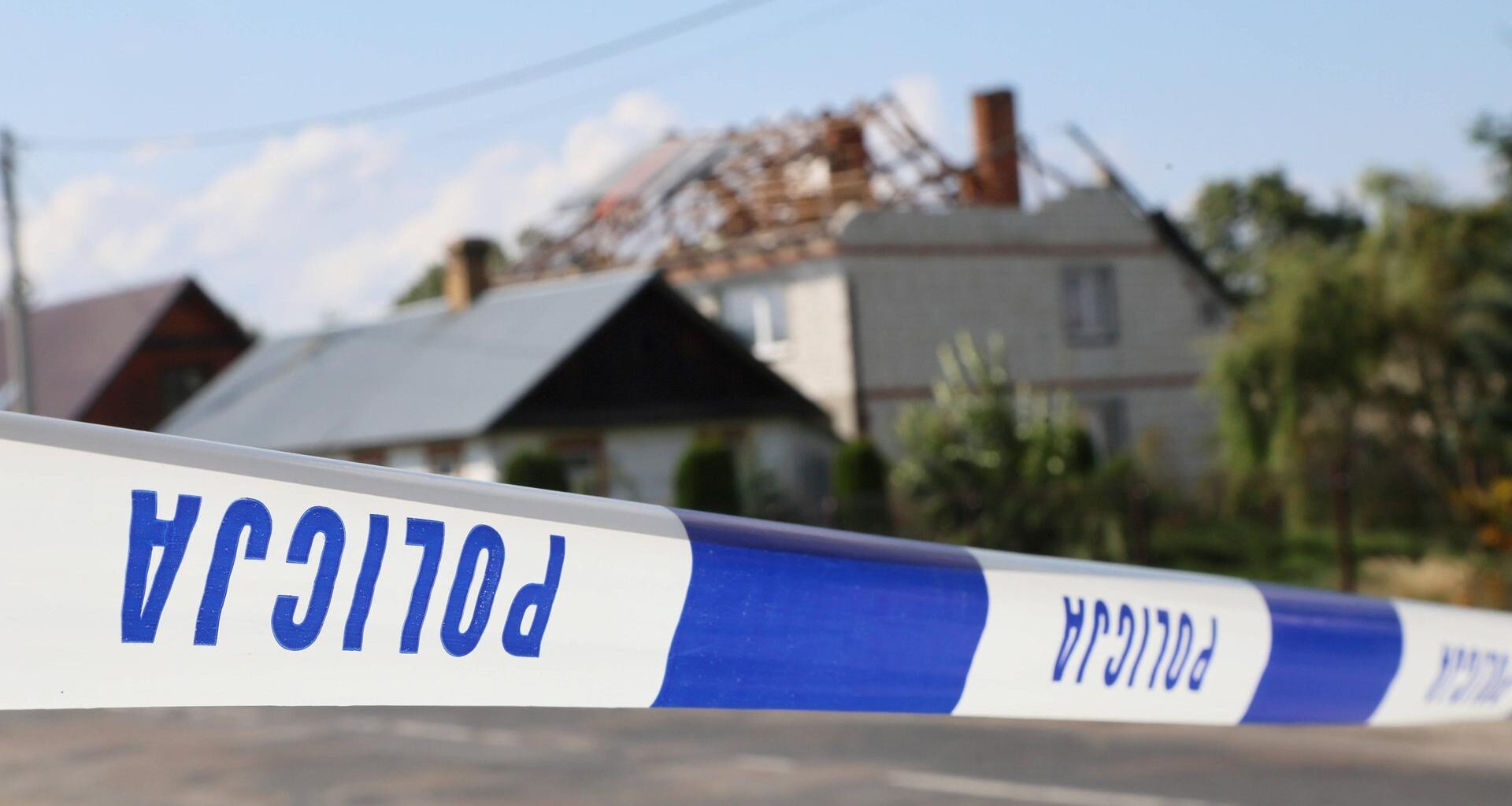 Hinter dem Absperrband der Polizei sieht man ein beschädigtes Haus in einem polnischen Dorf.