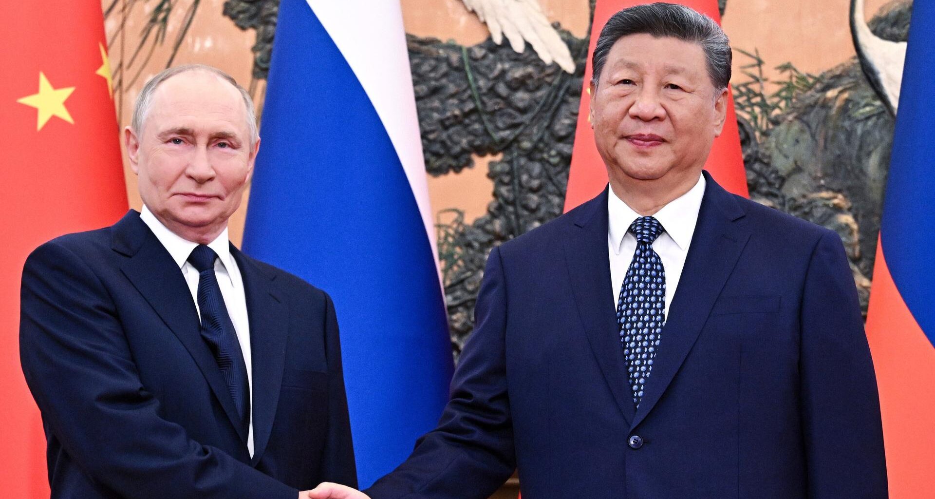 Der russische Präsident Wladimir Putin (l.) und Chinas Staatspräsident Xi Jinping geben sich vor ihrem Treffen in der Großen Halle des Volkes in Peking die Hand.