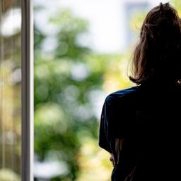 Symbolbild:Eine Frau steht in ihrer Wohnung an einem Fenster.(Quelle:picture alliance/dpa/F.Sommer)