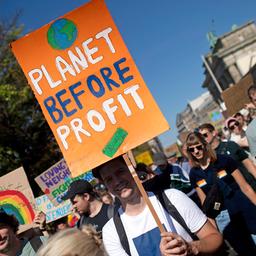 Demonstranten der Fridays For Future Bewegung mit Plakat Planet Before Profit bei der Kundgebung und Demonstration