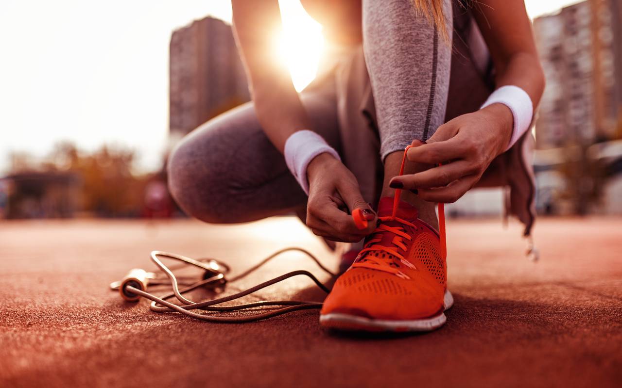 Eine Frau bereitet sich auf einen Lauf vor. Sie wird gleich joggen gehen.