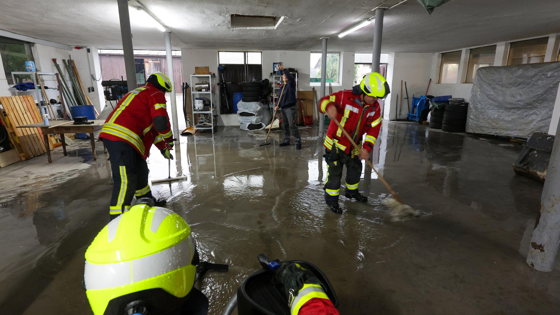 Einsatzkräfte der Feuerwehr sind nach einem Unwetter mit Wassersaugern in einem überfluteten Gebäude im Einsatz.