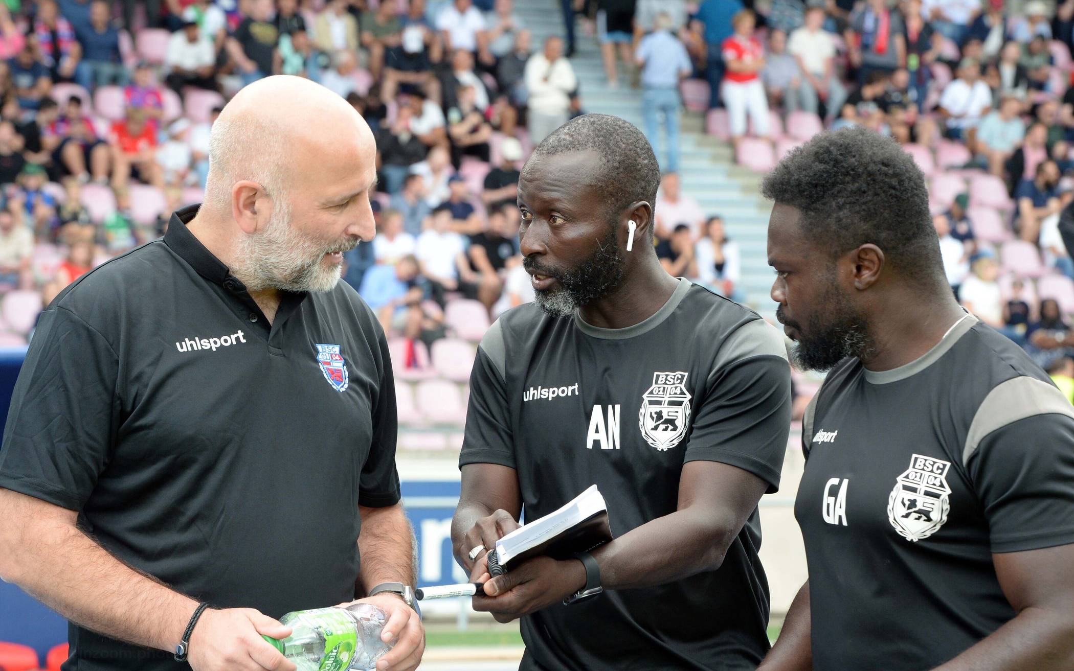 Björn Mehnert (links) im Gespräch mit seinen Co-Trainern Adama Niang (Mitte) und Gordon Addai.