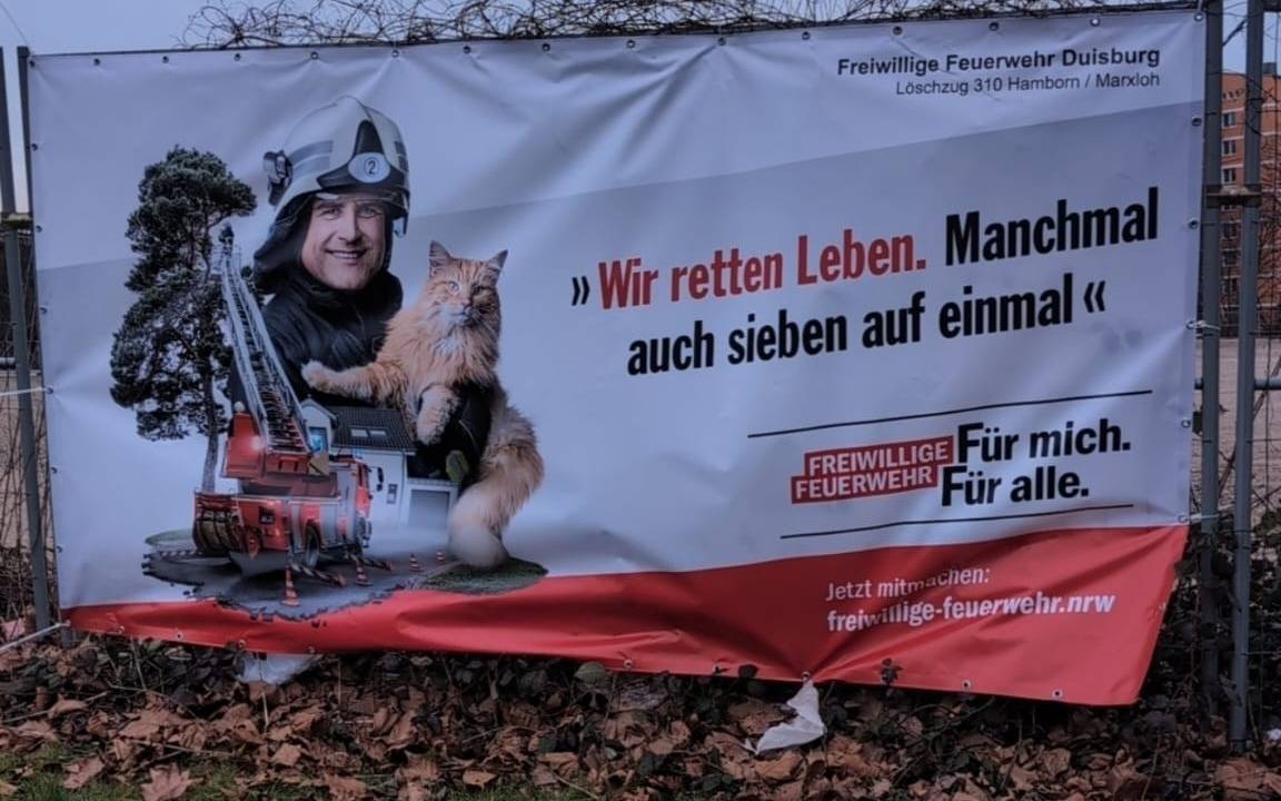 Ein neues Feuerwehrbanner an einem Bauzaun