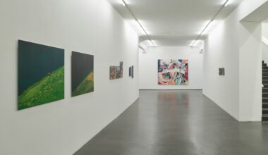 Blick in einen weißen Flur. An den Wänden hängen Gemälde.