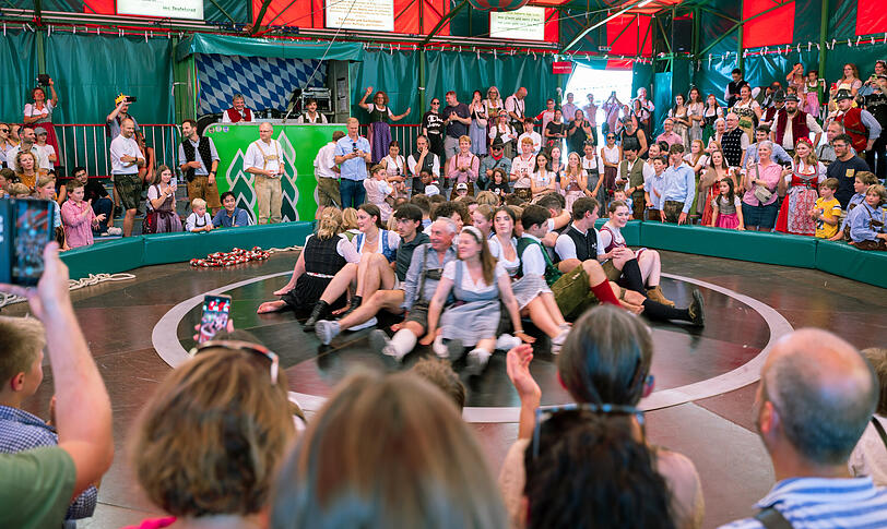 Besucherinnen und Besucher sitzen auf dem Teufelsrad auf dem Oktoberfest. Besucherinnen und Besucher sitzen auf dem Teufelsrad auf dem Oktoberfest.