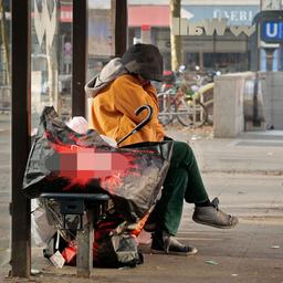Symbolbild: Eine wohnungslose Frau sitzt im Stadtteil Steglitz mit ihrer wenigen Habe an einer Bushaltestelle. (Quelle: dpa/Steinberg)