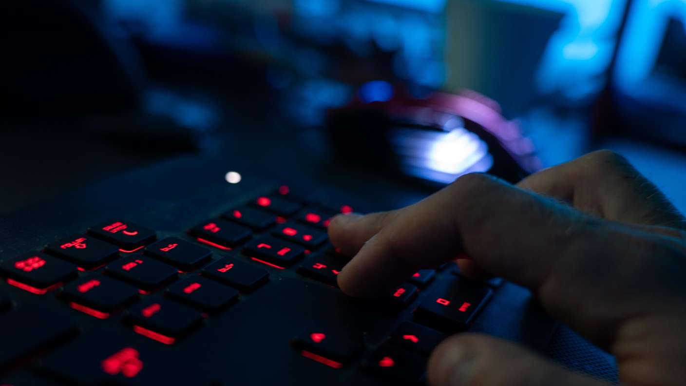 Ein Mann tippt auf einer leuchtenden Tastatur: Ein Hackerangriff erschüttert die Bundesagentur für Arbeit. 