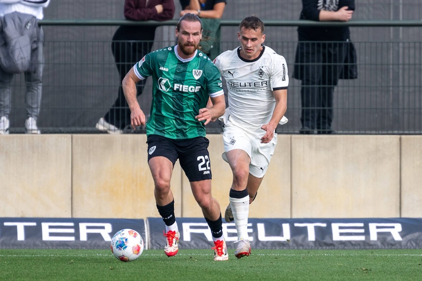 Jan Urbich im weißen Trikot und ein Preußen-Spieler im Zweikampf