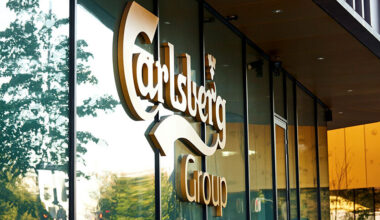 Außenansicht eines Gebäudes mit Carlsberg-Logo auf einer Glasfassade.