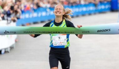 Zwei junge Frauen laufen bei sommerlichem Wetter auf einer Straße durch eine waldige Landschaft.