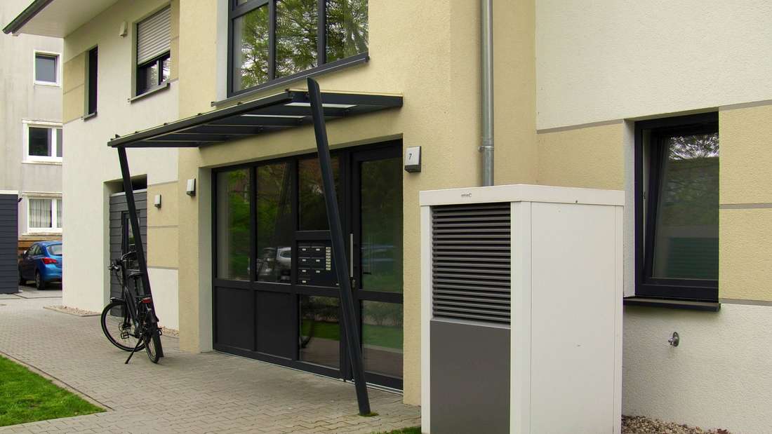Eine Wärmepumpe der Firma Brötje vor einem Mehrfamilienhaus. 