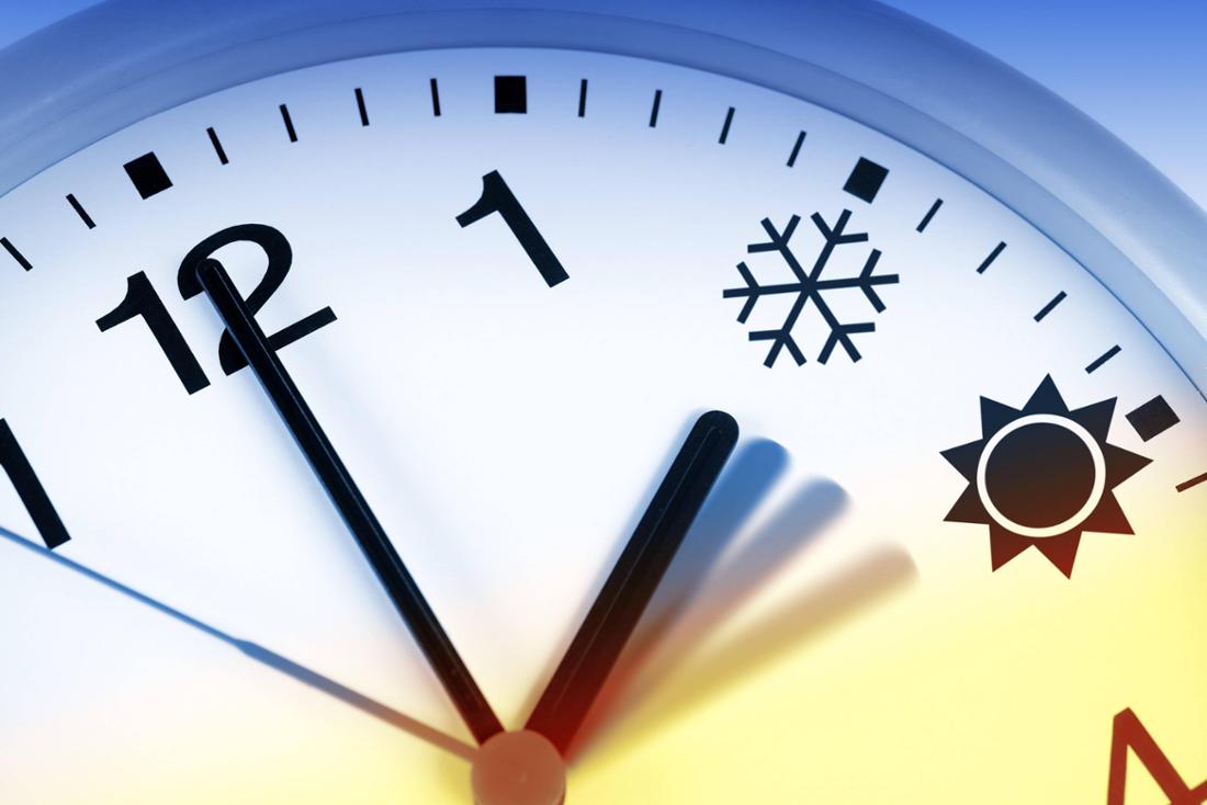 Symbolfoto einer Uhr, die Zahlen zwei und drei durch einen Eiskristall und eine Sonne ersetzt.