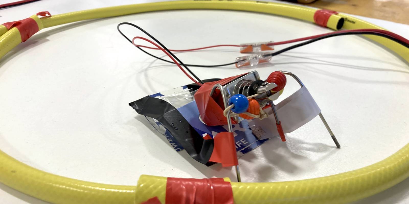 Tonerzeugender Gegenstand aus Alltagsmaterialien wie zum Beispiel Wasserschlauch und Klebeband. Außerdem ist Elektrotechnik verbaut.