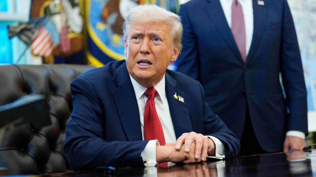Donald Trump sitzt am Schreibtisch im Oval Office und spricht