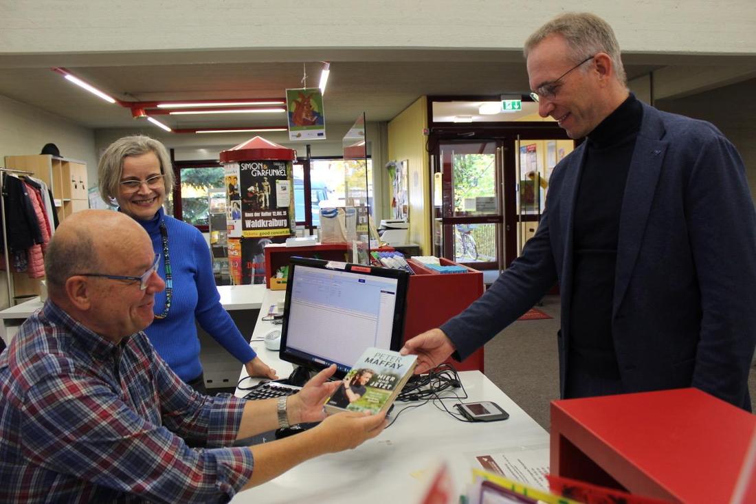 Büchereileiterin Bianca Mertin und Ehrenamtler Lothar Schimek kümmern sich um die Ausleihe von Bürgermeister Robert Pötzsch.