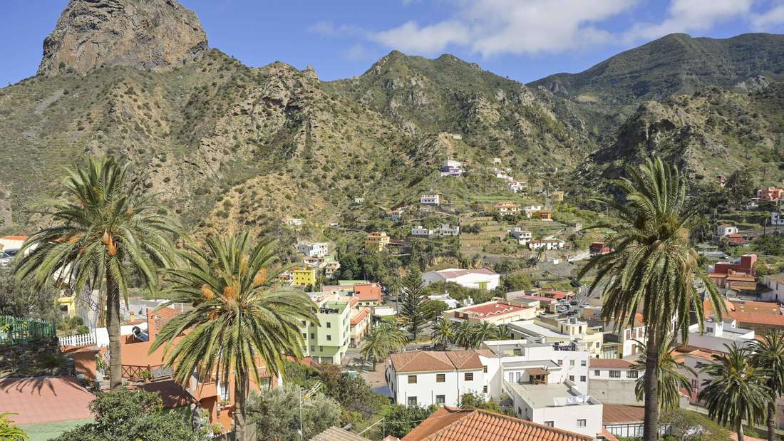 Stadtansicht von Vallehermoso auf La Gomera mit Palmen, Häusern und Berg im Hintergrund