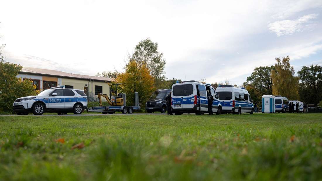 Polizeiautos stehen auf einer Wiese in Tauche