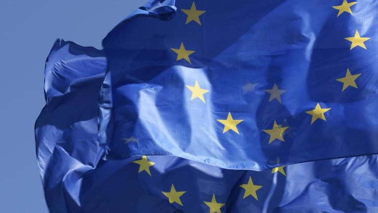 Zwei nebeneinander wehende Europafahnen.
