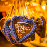 Lebkuchenherzen hängen an einem Stand mit der Aufschrift „Oktoberfest“