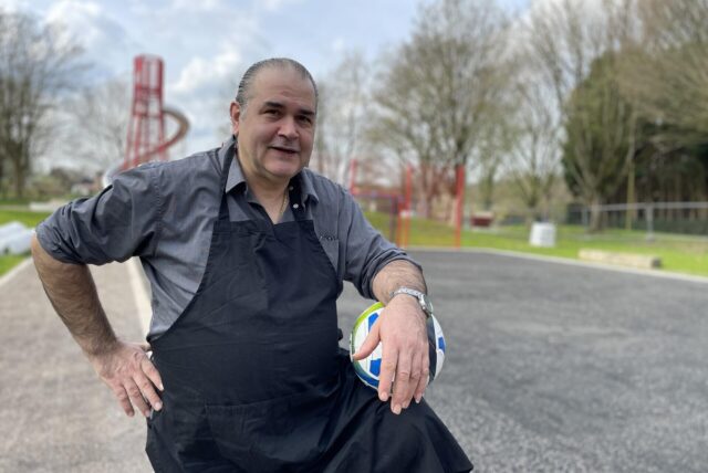 Gianni de Nitto, Pizzabäcker und Spielplatz-Pate, steht auf dem damals noch nicht eröffneten neuen Spielplatz „Varziner Straße“ in Huckarde und hält einen Fußball fest.