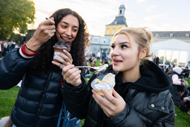 Zwei Mädchen essen Pudding mit einer Gabel