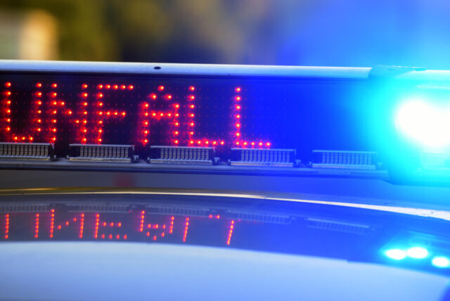 Auf einem Polizeifahrzeug warnt eine Leuchtschrift vor einer Unfallstelle.