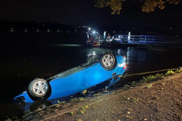 Ein Auto liegt am Ufer des Baldeneysees auf dem Dach.