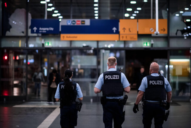 Polizisten laufen durch den Bahnhof.