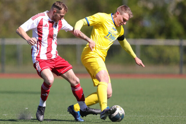 Ein Spieler behauptet den Ball im Zweikampf mit einem gegnerischen Spieler.