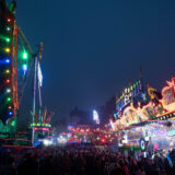 Menschen laufen zwischen Fahrgeschäften über die Allerheiligenkirmes in Soest, eine der größten Kirmessen in NRW.
