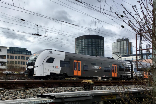 Ein RRX fährt vor der Kulisse der Dortmunder City über die Bahnbrücke am Burgtor.