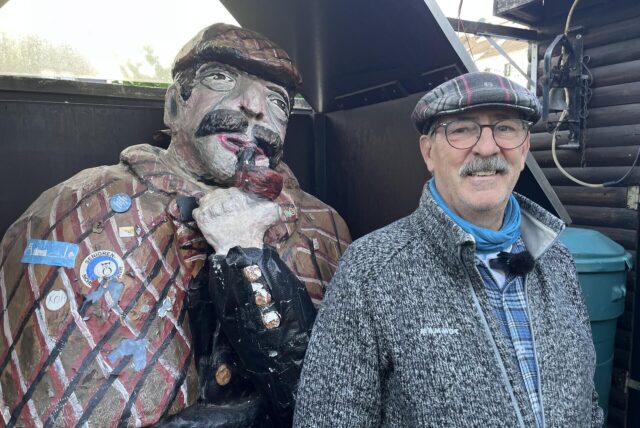 Figur des Sherlock Holmes im Garten neben Andreas Dickel