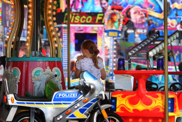 Ein Mädchen fährt auf dem beliebten Kinderkarussell auf der Herbstkirmes in Essen-Steele.