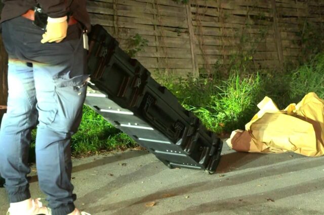 Ermittler mit einem Waffencontainer.