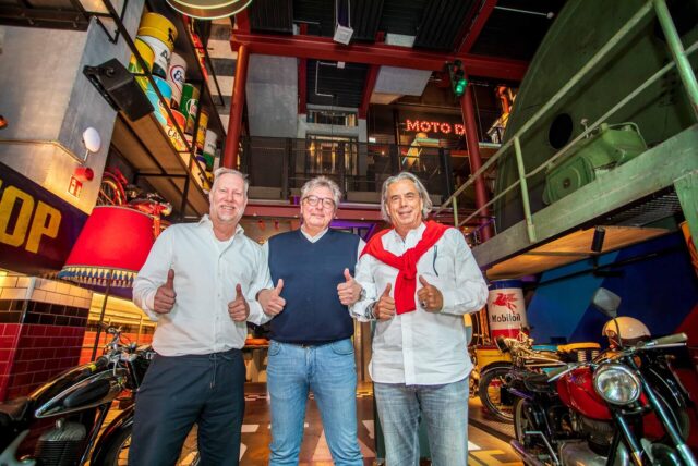 Die Betreiber Carsten Kubacki, Thomas Block und Hubert Sterzinger stehen im Foyer des Restaurants Foodgarage Moto59 in Herten.