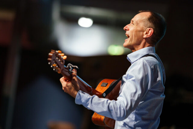 Stefan Nussbaum mit Gitarre und singend.