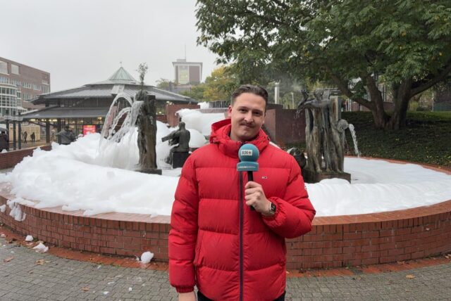Breaking-Reporter Tim Hübbertz vor einem mit Schaum überquellenden Brunnen im Stadtgarten in Dortmund.