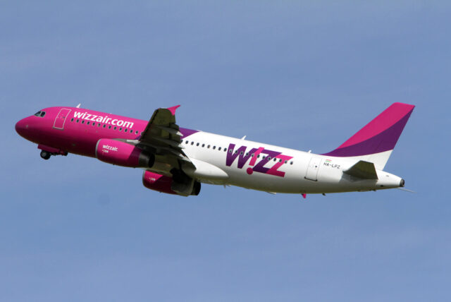 Auf dem Bild ist ein Flieger von Wizz Air, der gerade durch die Luft fliegt.