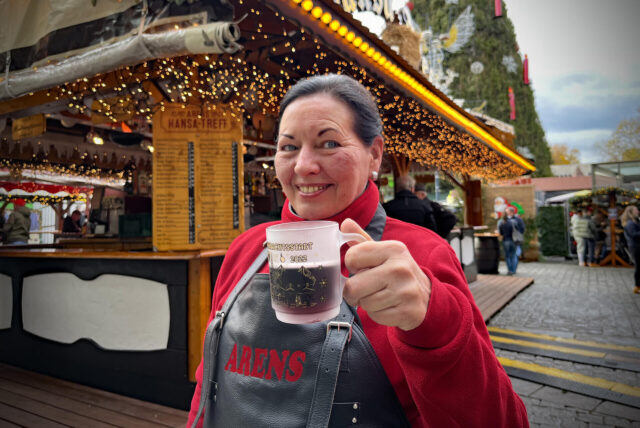 Luise Arens hält eine Tasse mit Glühwein in der Hand und steht auf dem Weihnachtsmarkt in Dortmund.