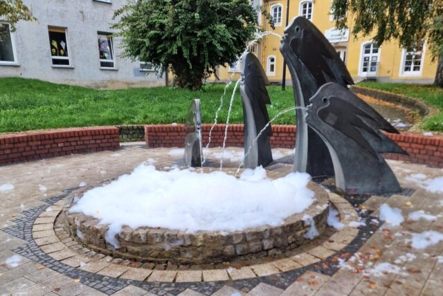 Schaumteppich auf dem Becken des Hexenbrunnens auf dem Lütgendortmunder Heinrich-Sondermann-Platz.