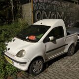 Dieses Leichtfahrzeug in Dortmund-Eving steht verdreckt und von Pflanzen zugewuchert am Rande der Derner Straße.