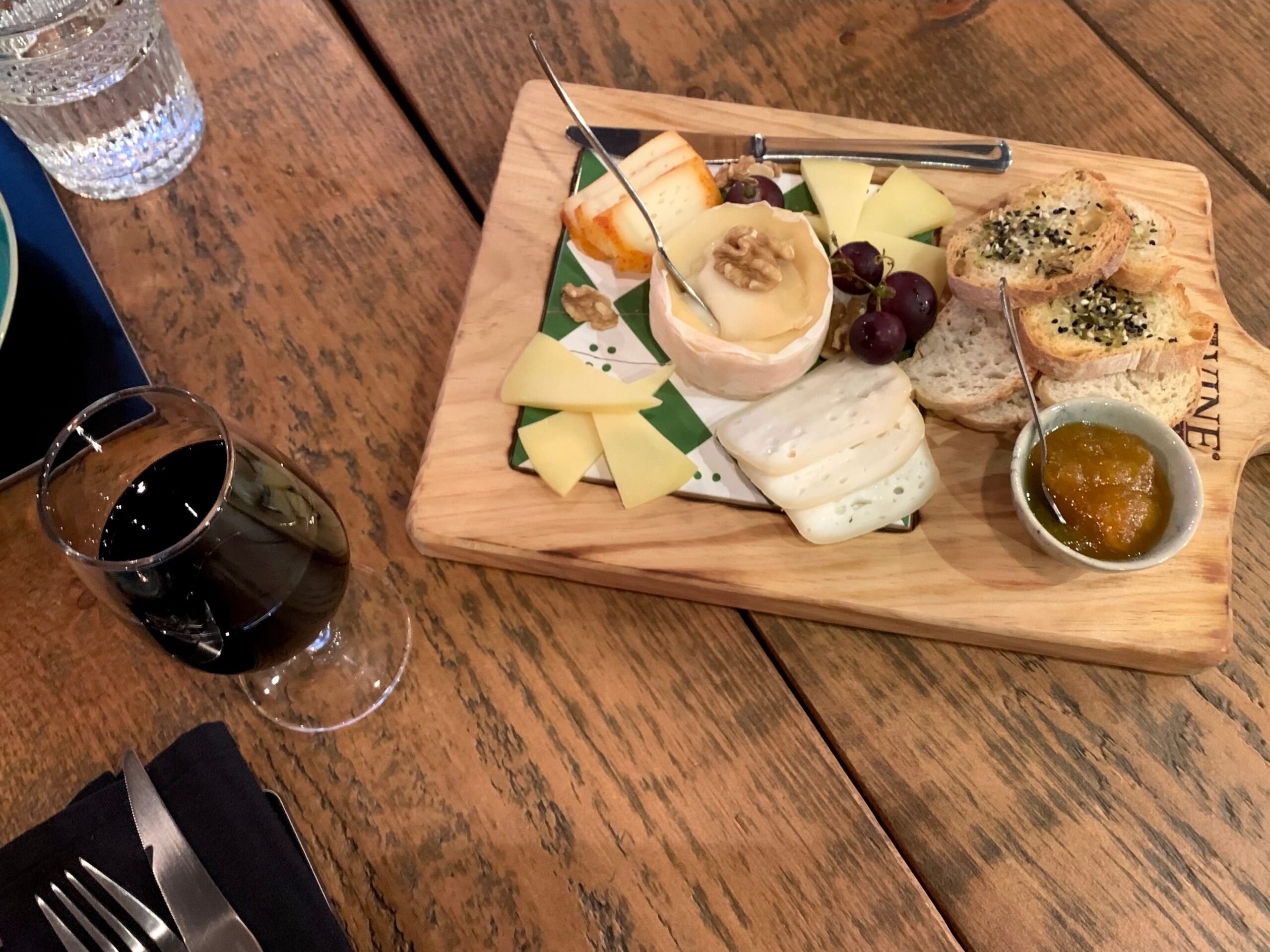 A charcuterie board and glass of red wine at The Wine Box in Porto, Portugal.