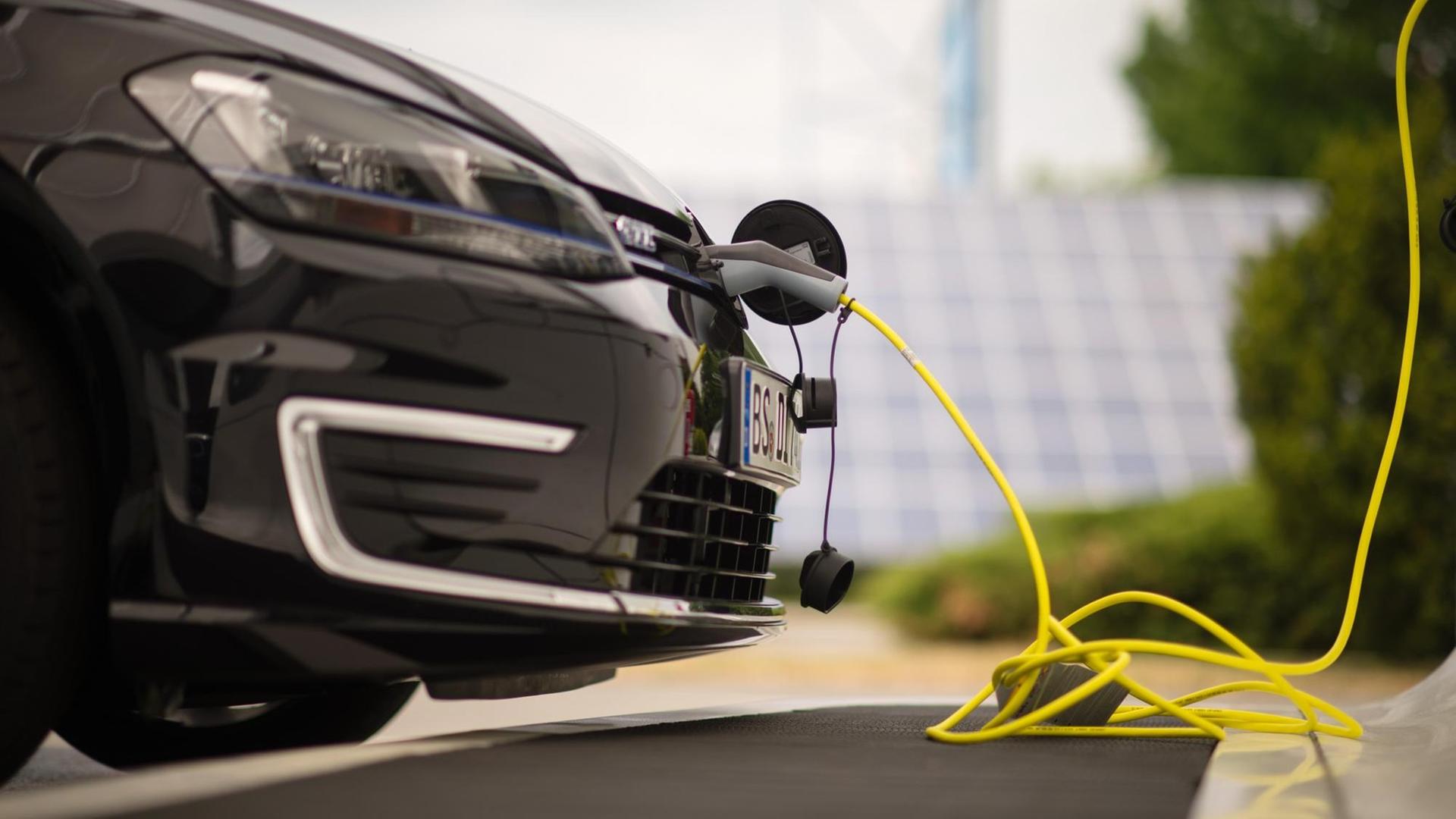 Ein Hybrid-Fahrzeug tankt Strom. 