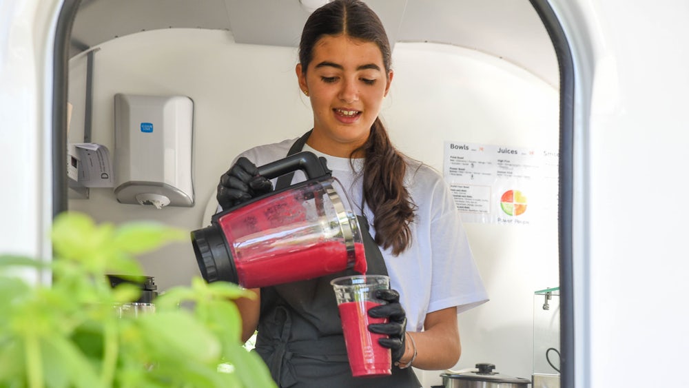 Alina Schoeller schenkt einen Smoothie aus Zutaten wie Rote Beete, Himbeeren und Reismilch ein.